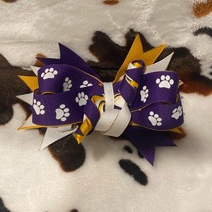 Purple, white, and gold small hair bow.